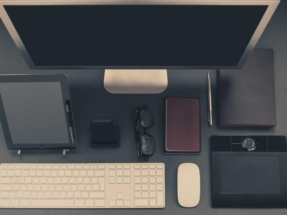A laptop and coffee on a desk in warm morning light